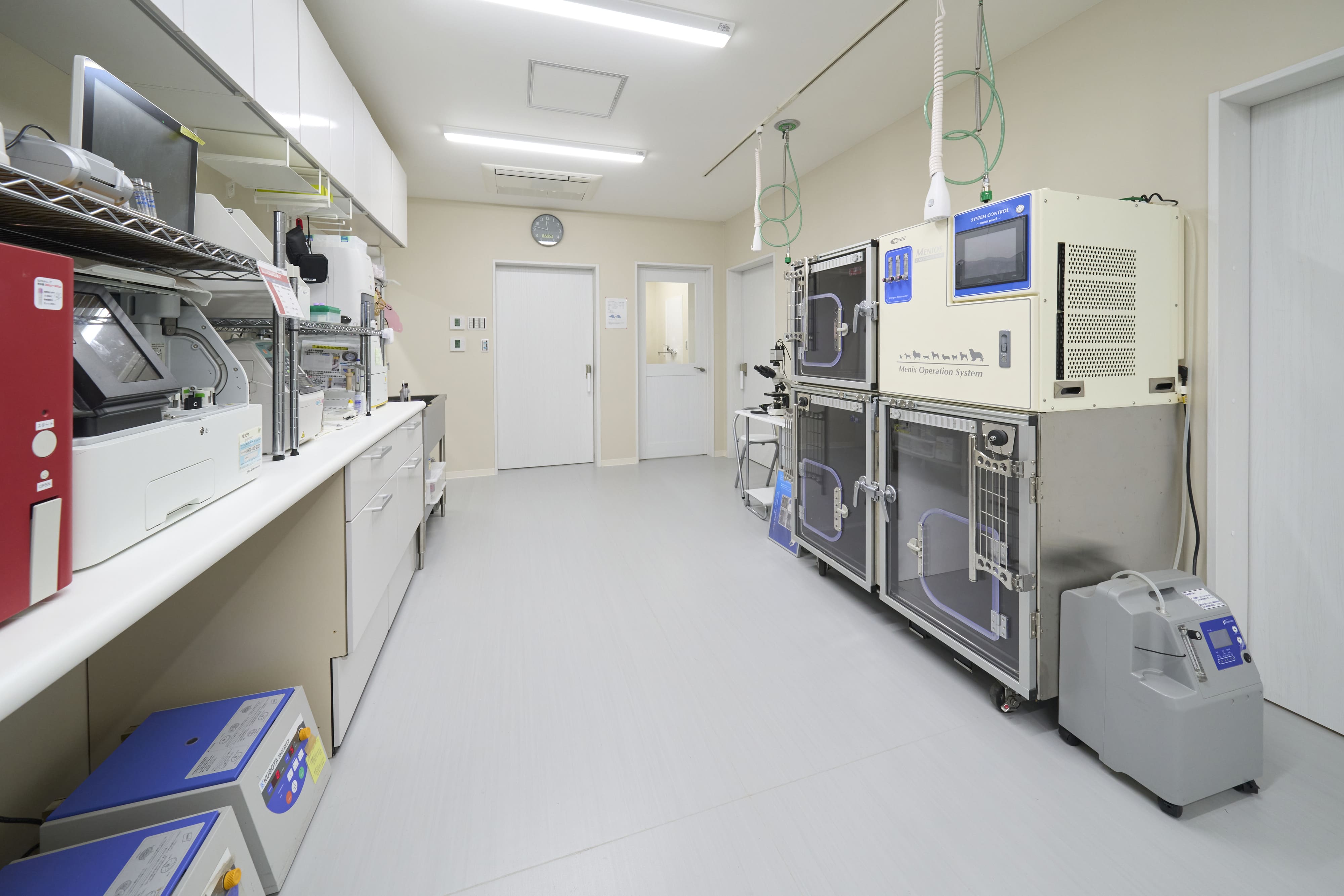 各種検査機器と動物用の酸素ケージが配置された専用室