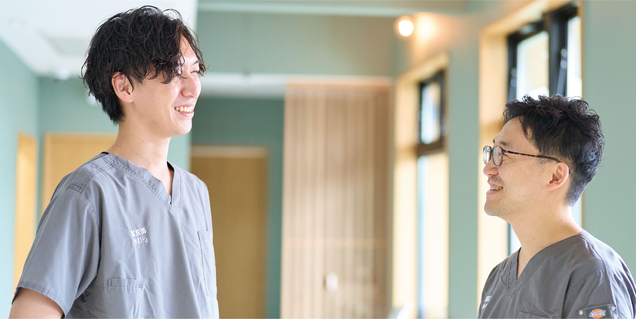スタッフ2人が院内で笑顔で会話している様子